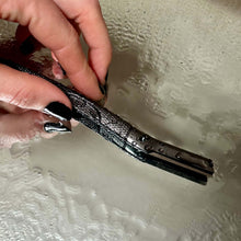 Load image into Gallery viewer, Woman holding a matte black metal dermaplaner facial razor - Shoreline Shaving