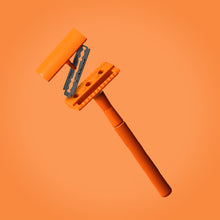 Load image into Gallery viewer, A three piece orange safety razor with blade floating on an orange background - Shoreline Shaving