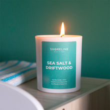 Load image into Gallery viewer, Sea salt & driftwood natural soy wax candle next to a blanket by Shoreline Shaving