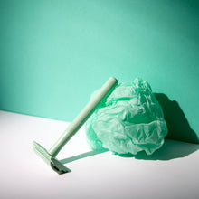 Load image into Gallery viewer, Mint green reusable safety razor leaning a green ball of tissue - Shoreline Shaving