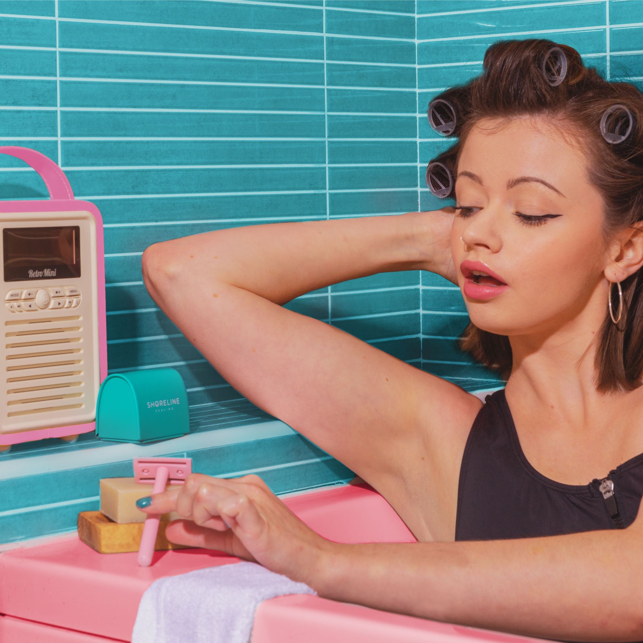 A women with her hair in rollers shaving with a safety razor from an ultimate shaving kit gift set - Shoreline Shaving