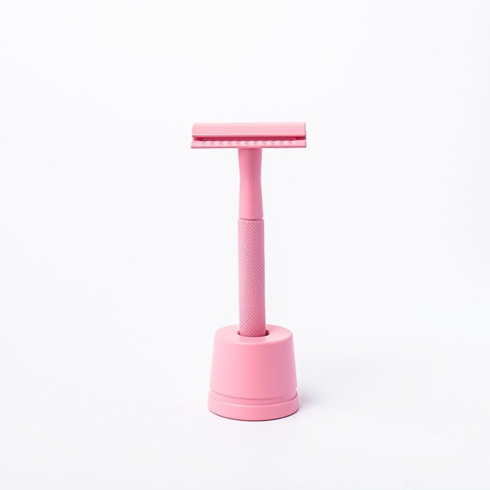 Pastel pink reusable metal safety razor inside a pink razor stand - Shoreline Shaving