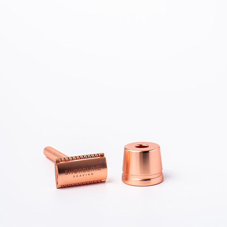 Rose gold reusable metal safety razor next to a rose gold razor stand - Shoreline Shaving