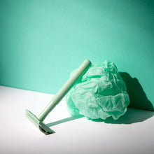 Load image into Gallery viewer, Mint green reusable safety razor leaning a green ball of tissue - Shoreline Shaving
