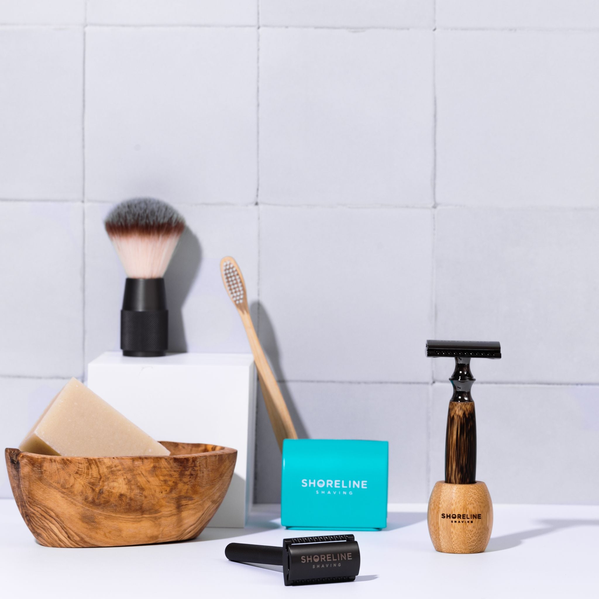 Storm grey bamboo safety razor in matching bamboo stand, surrounded by bathroom accessories including shaving soap, toothbrush and blade tin - Shoreline Shaving